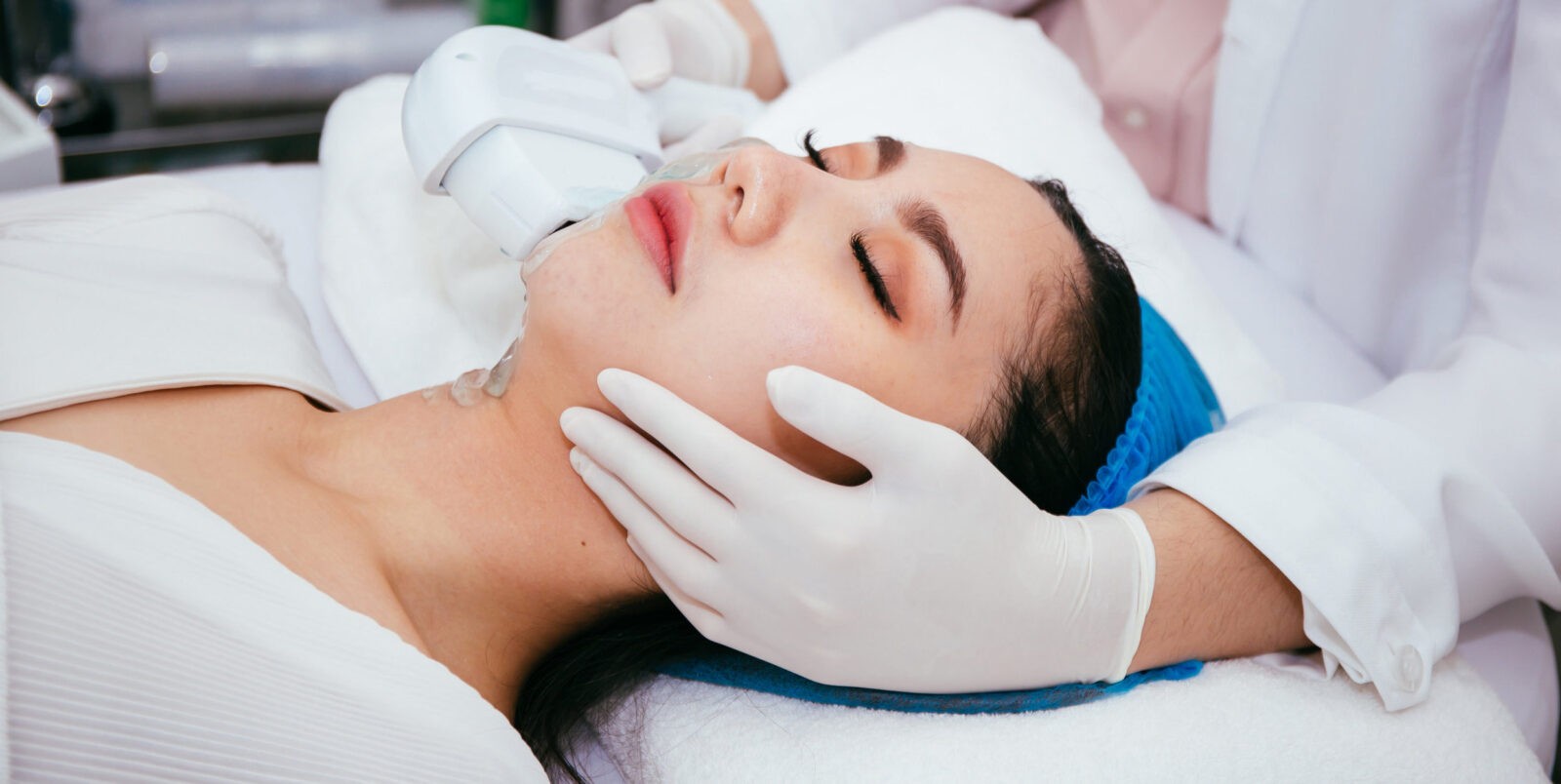 Young Asian woman getting IPL and laser treatment by beautician at beauty clinic