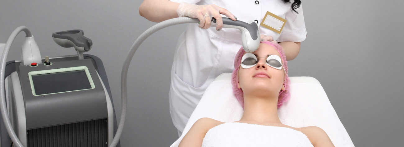 Skincare laser pigment color change at day spa being preformed on face of woman by technician.
