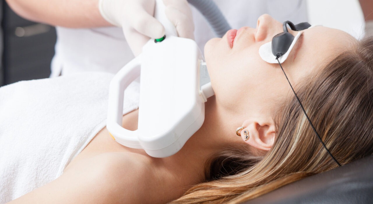 woman during face laser therapy in cosmetics closeup