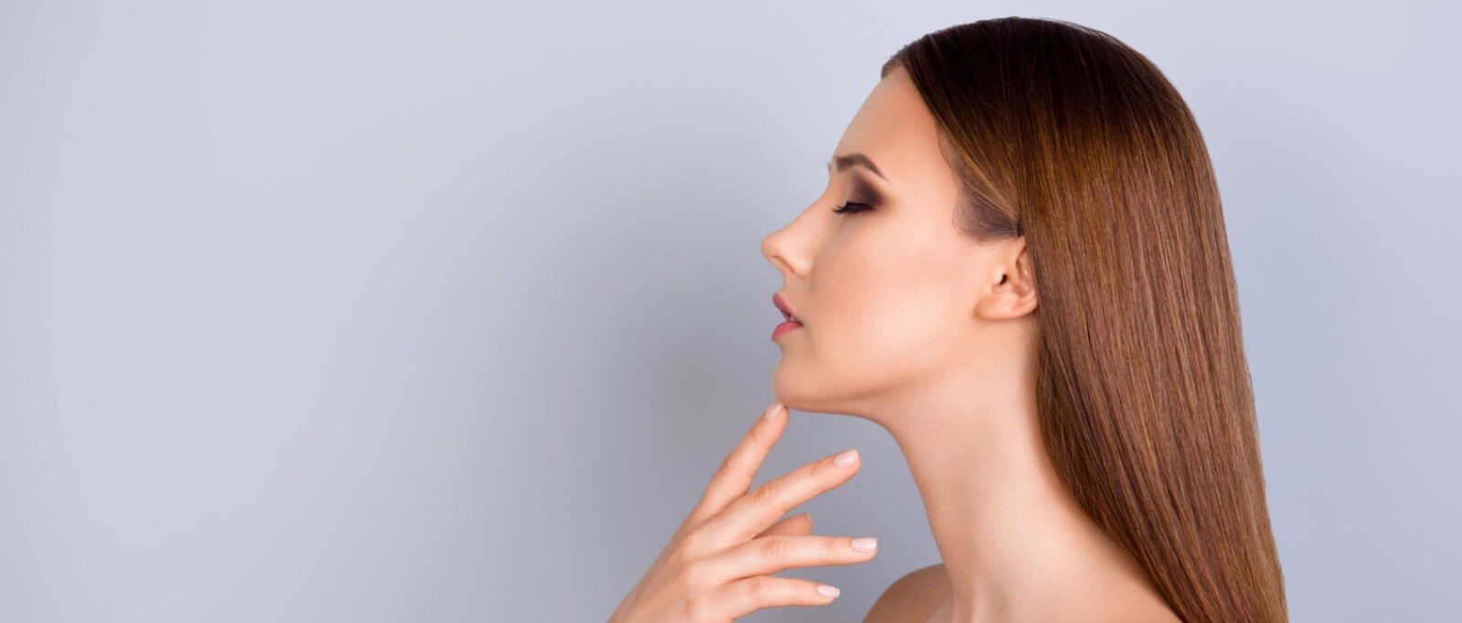 Young girl is touching gently her shining healthy skin