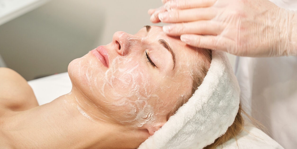 A women getting a customized facial scrub treatment at a dermatology spa.