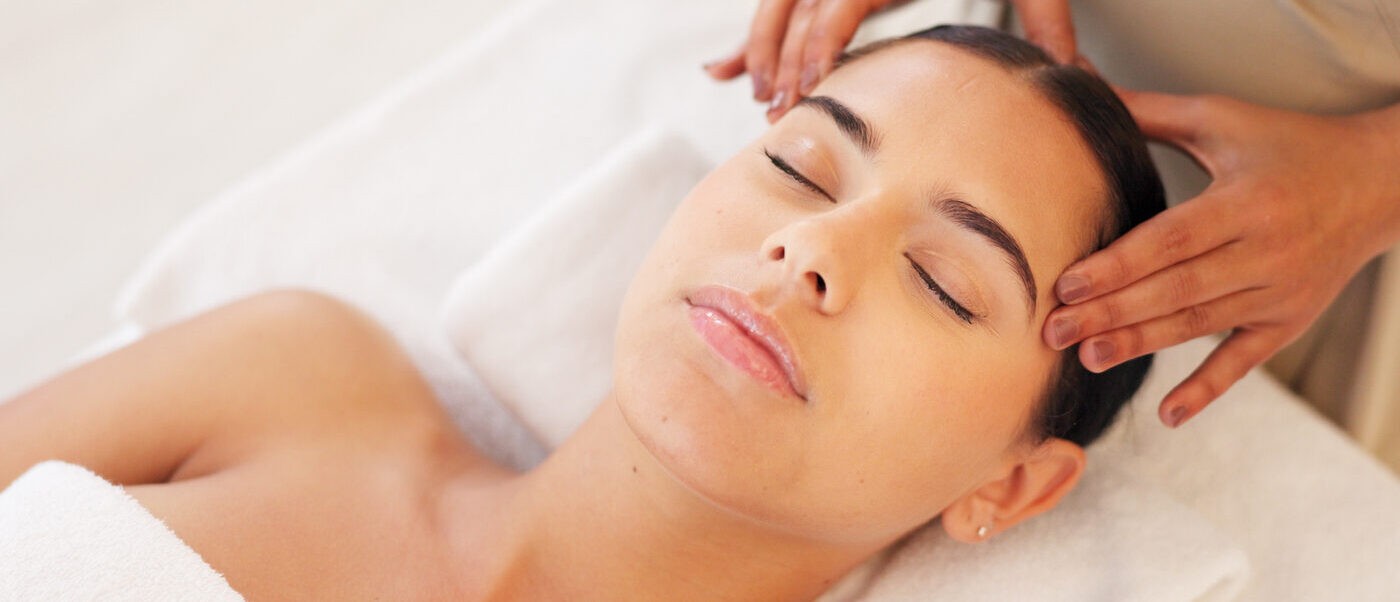 A calm woman enjoying a relaxing facial treatment in a dermatology clinic.